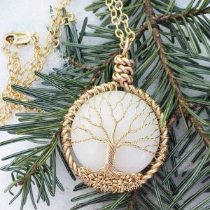 Pendentif en lait maternel avec arbre de vie en fil doré, symbole de croissance, d’ancrage et du lien entre la mère et l’enfant