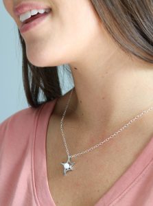 Collier en lait maternel avec pendentif étoile porté autour du cou, symbole de protection, d’espoir et de lien maternel