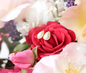 Boucles d’oreilles en lait maternel en forme de goutte avec contour doré, symbolisant l’amour maternel et la douceur