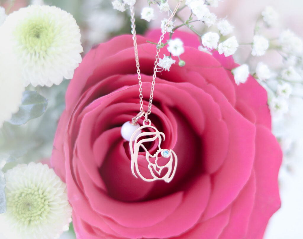 Pendentif avec perle de lait maternel et pierre de naissance.