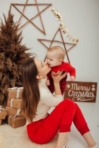 Une jeune maman et son bébé posant lors d'une séance photo spéciale noël.