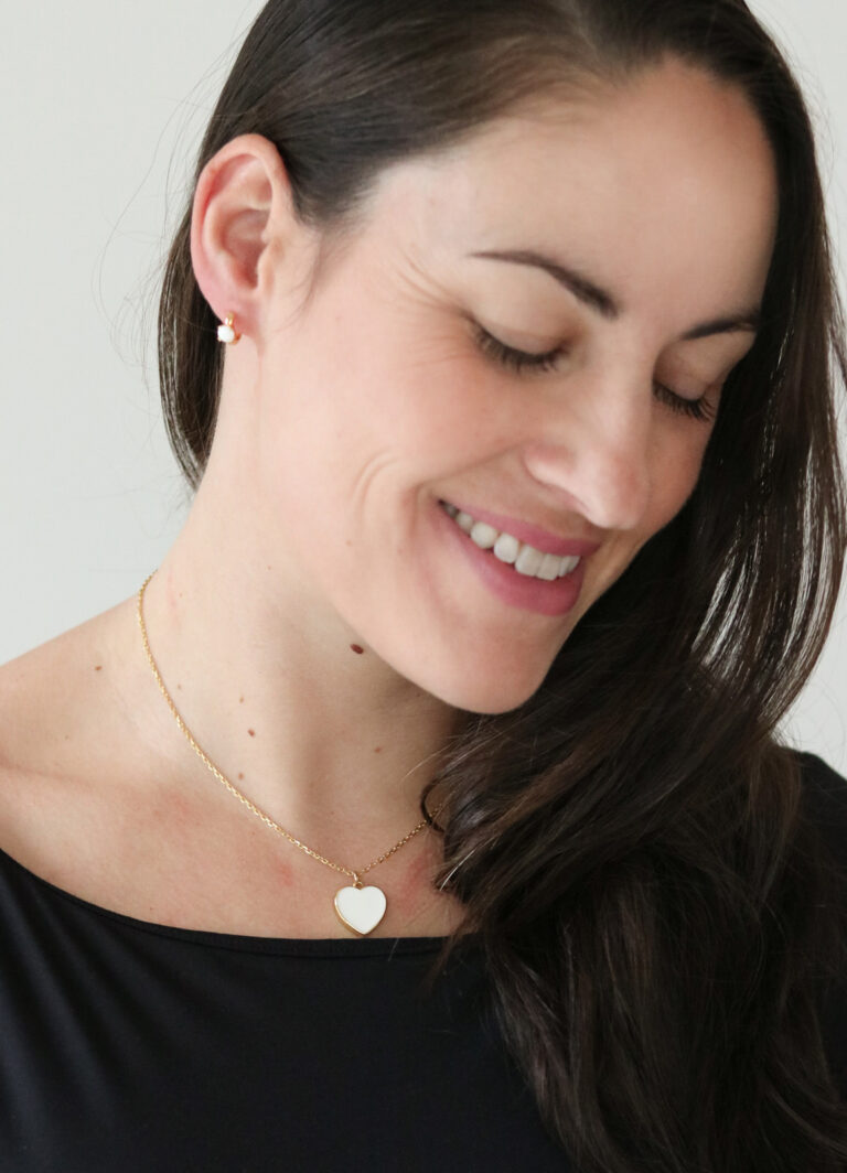 Collier souvenir avec un pendentif en forme de cœur en lait maternel porté par une maman, un bijou symbolique pour honorer l'histoire d'un bébé arc-en-ciel.