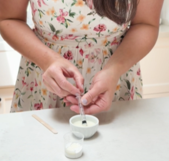 Jeune maman réalisant un bijou en lait maternel avec le kit DIY La Joie en Rose, création artisanale personnalisée pour conserver un souvenir d'allaitement.